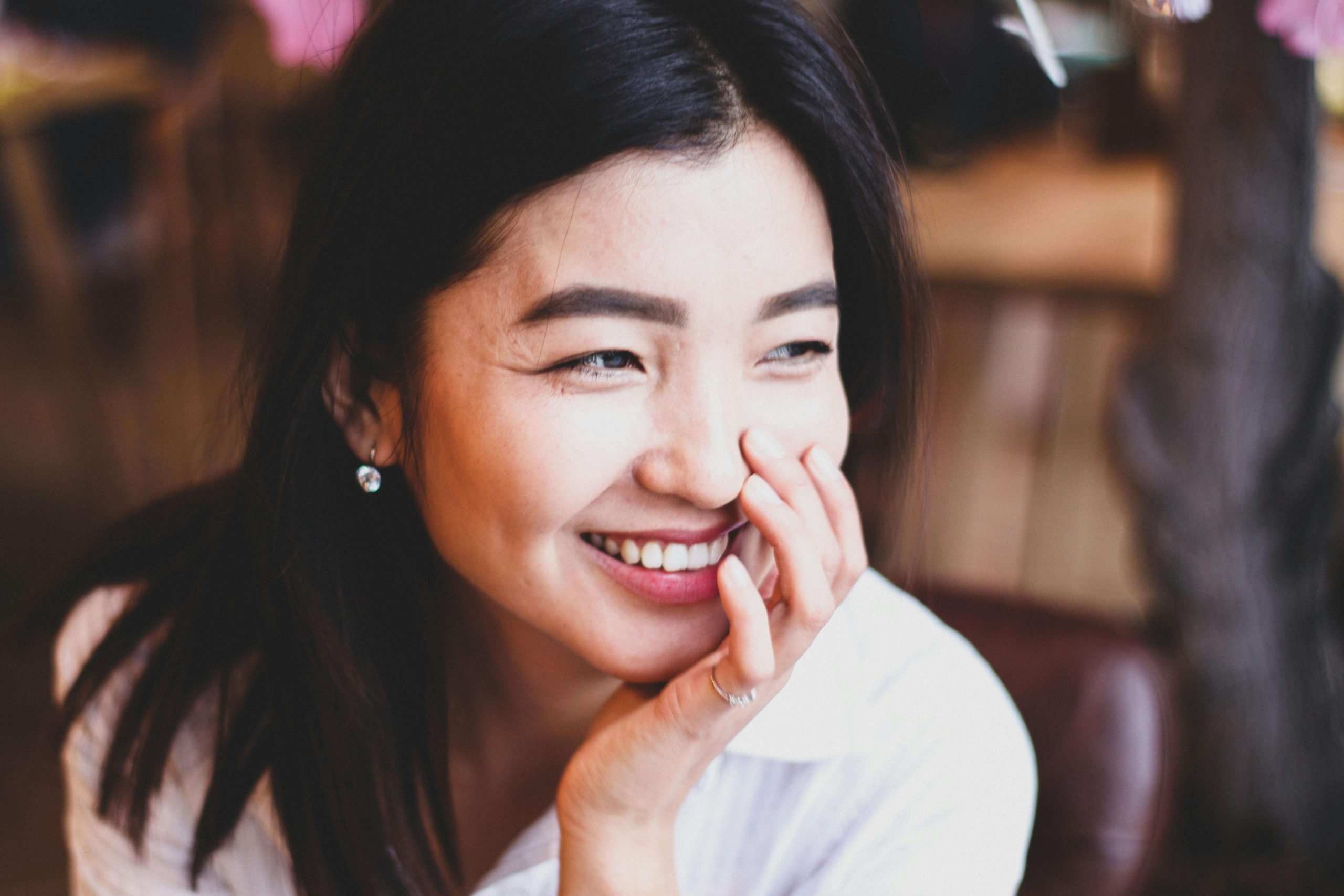 A young woman smiles warmly in a bright room, illustrating a sense of clarity and confidence often supported by effective ADHD treatment, such as medication management in Tempe, AZ.