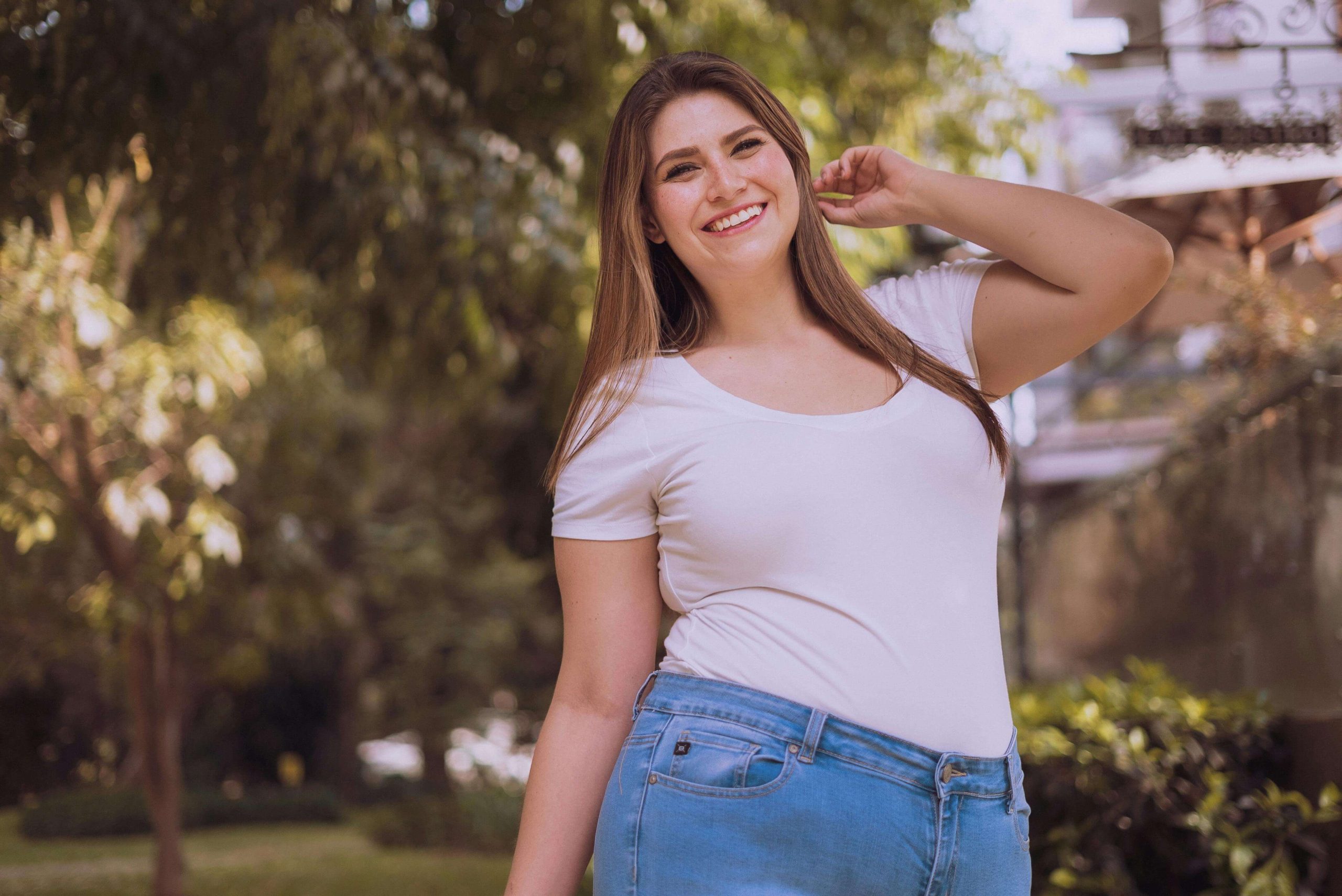A smiling woman standing outside in casual clothes, representing the sense of renewal and balance possible through ketamine infusion therapy in Tempe, AZ.