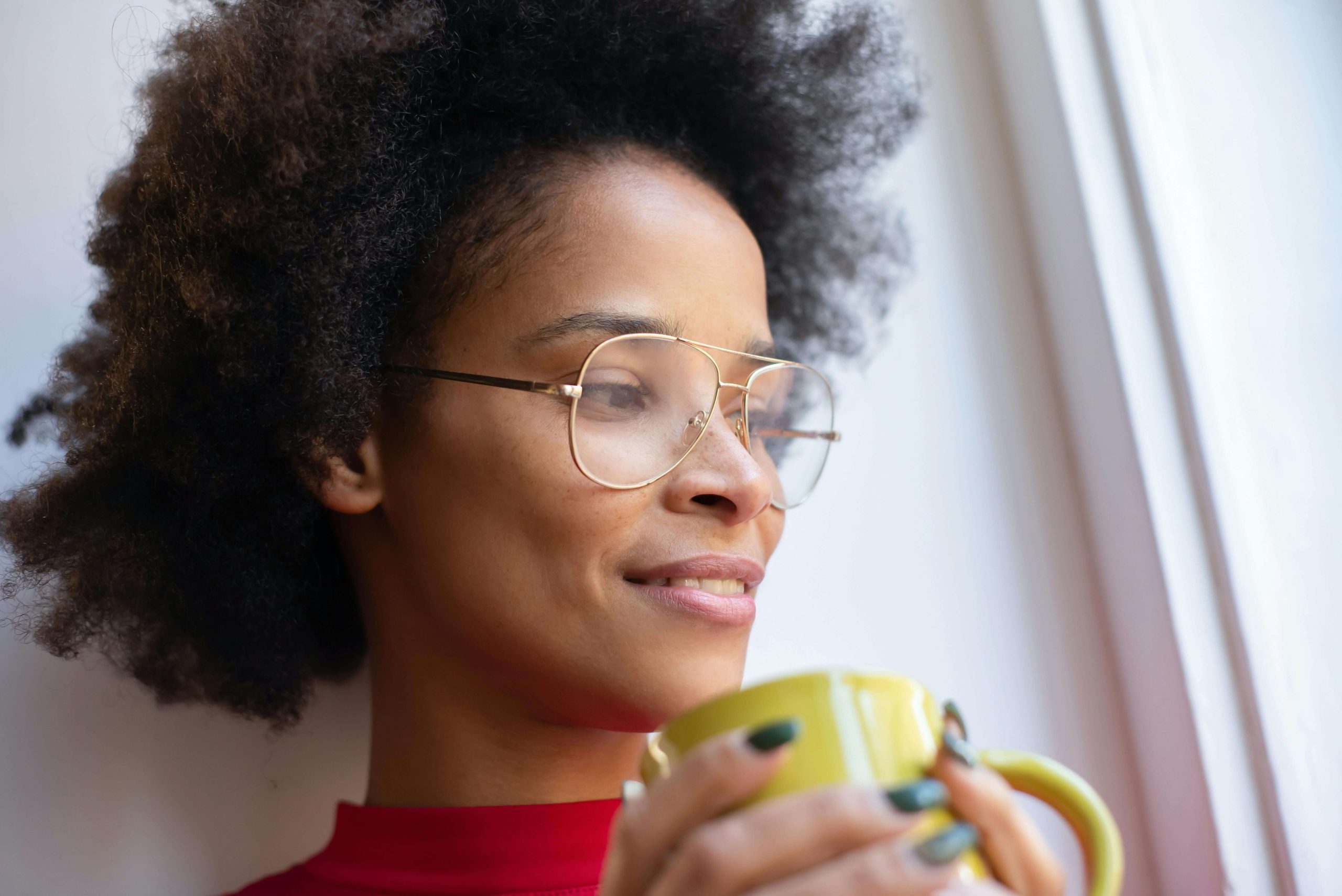 Person holding a warm drink by a window, representing calm moments and emotional healing supported by ketamine therapy in Tempe, AZ.