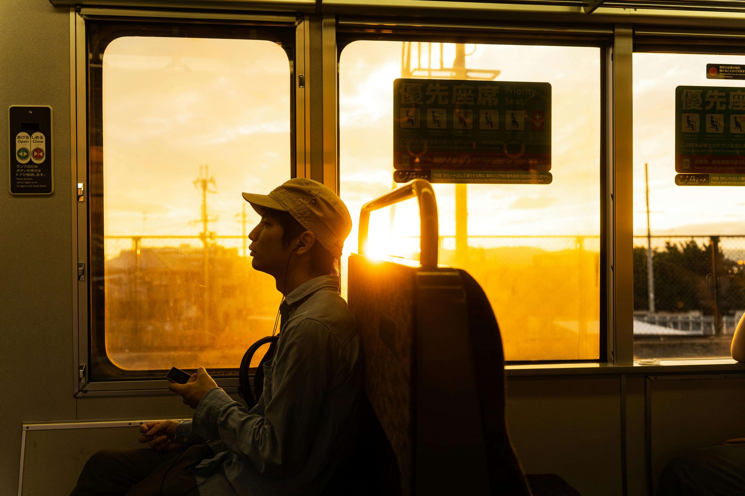 Man on Transport - psychiatric care tempe - tempe mental health services - psychiatrist tempe az - phx - phoenix - gilbert - scottsdale - mesa - arizona Man sitting on public transport during sunset, lost in reflection as golden light fills the train, portraying quiet introspection and the search for emotional balance through psychiatric care in Tempe, AZ.