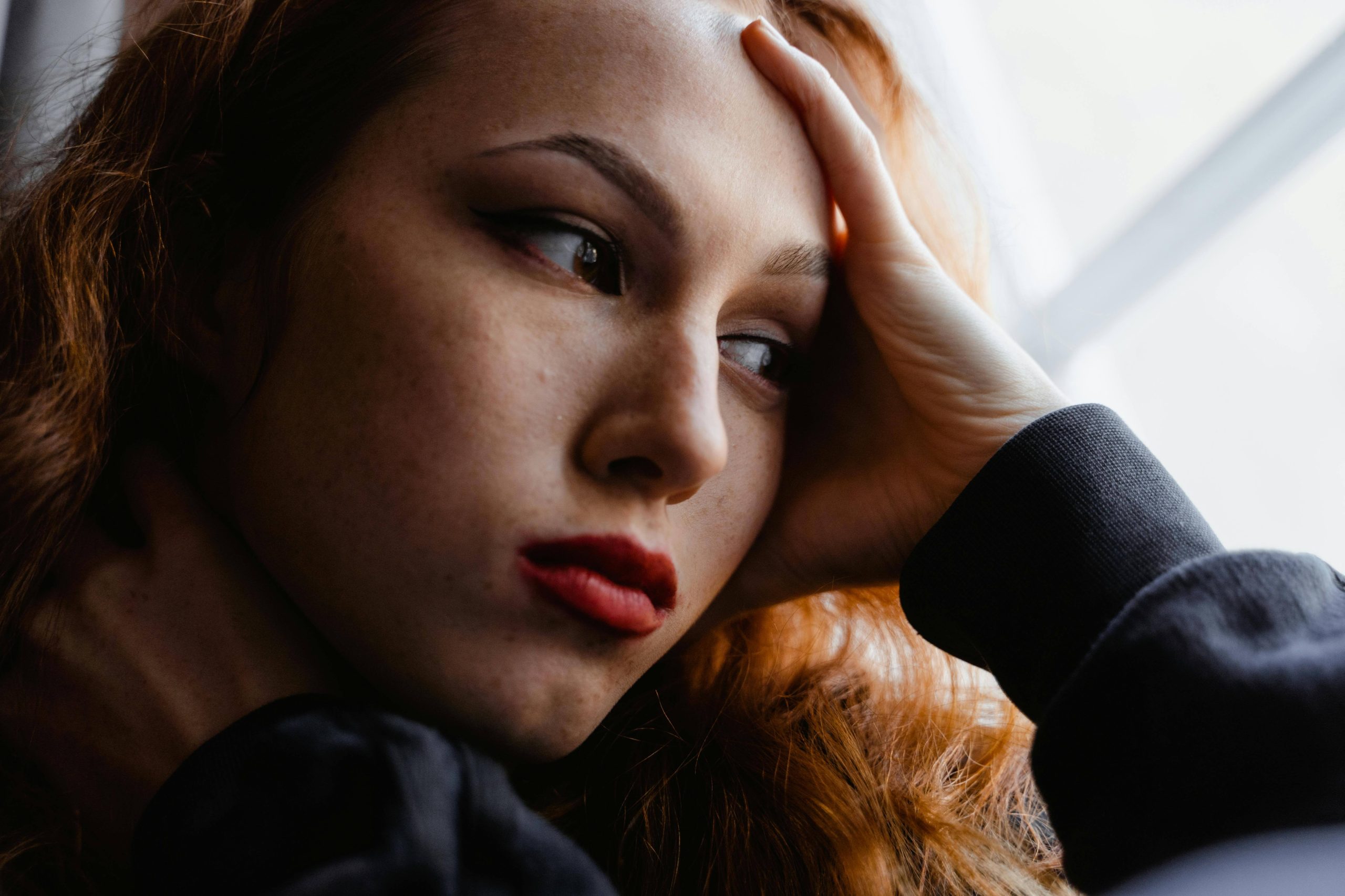 Close-up of a woman looking distant and overwhelmed, reflecting feelings of disconnection often addressed in ketamine therapy in Tempe, AZ.