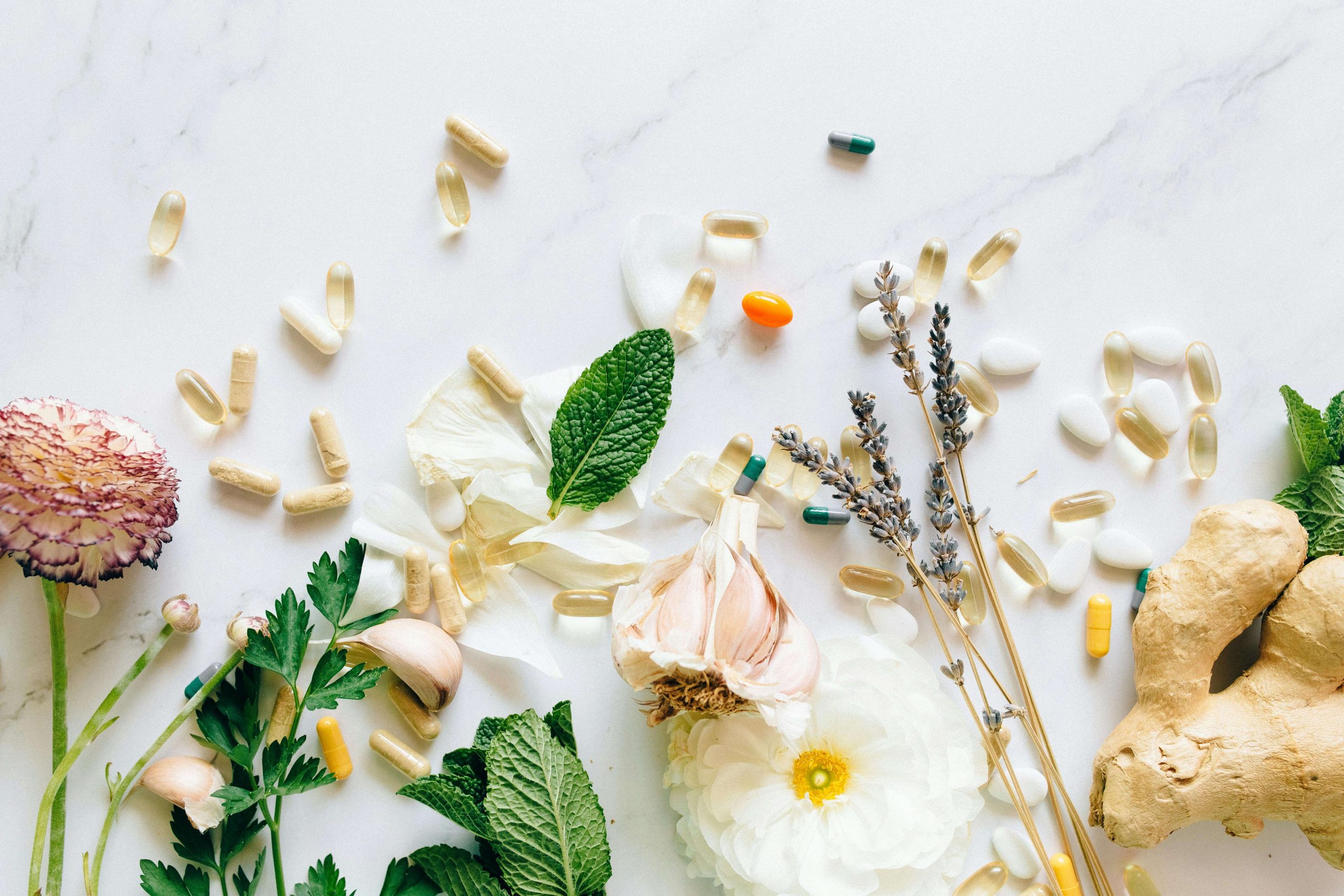 A flat lay of herbal remedies, vitamins, and supplements on a white surface, symbolizing holistic approaches that may complement bipolar disorder therapy in Tempe AZ.