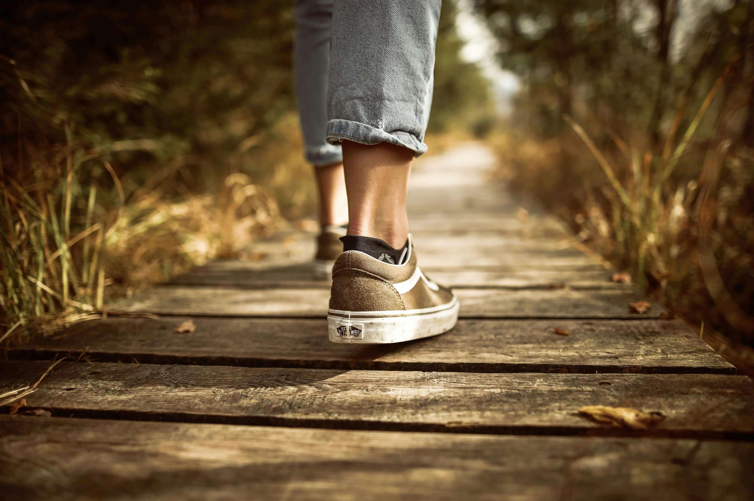 Close-up of a person’s shoes walking along a wooden path, reflecting the steady steps toward healing with ketamine infusion therapy in Tempe, AZ.