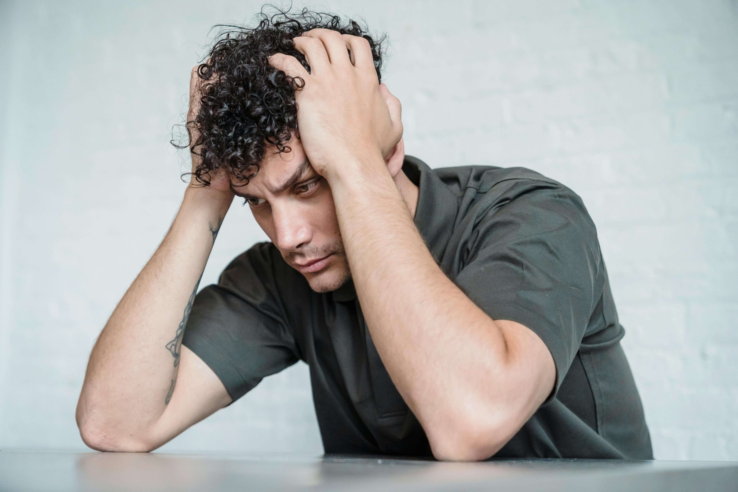 Man holding his head in distress, illustrating the emotional and mental struggles that intensive outpatient programs in Tempe, AZ help clients address.
