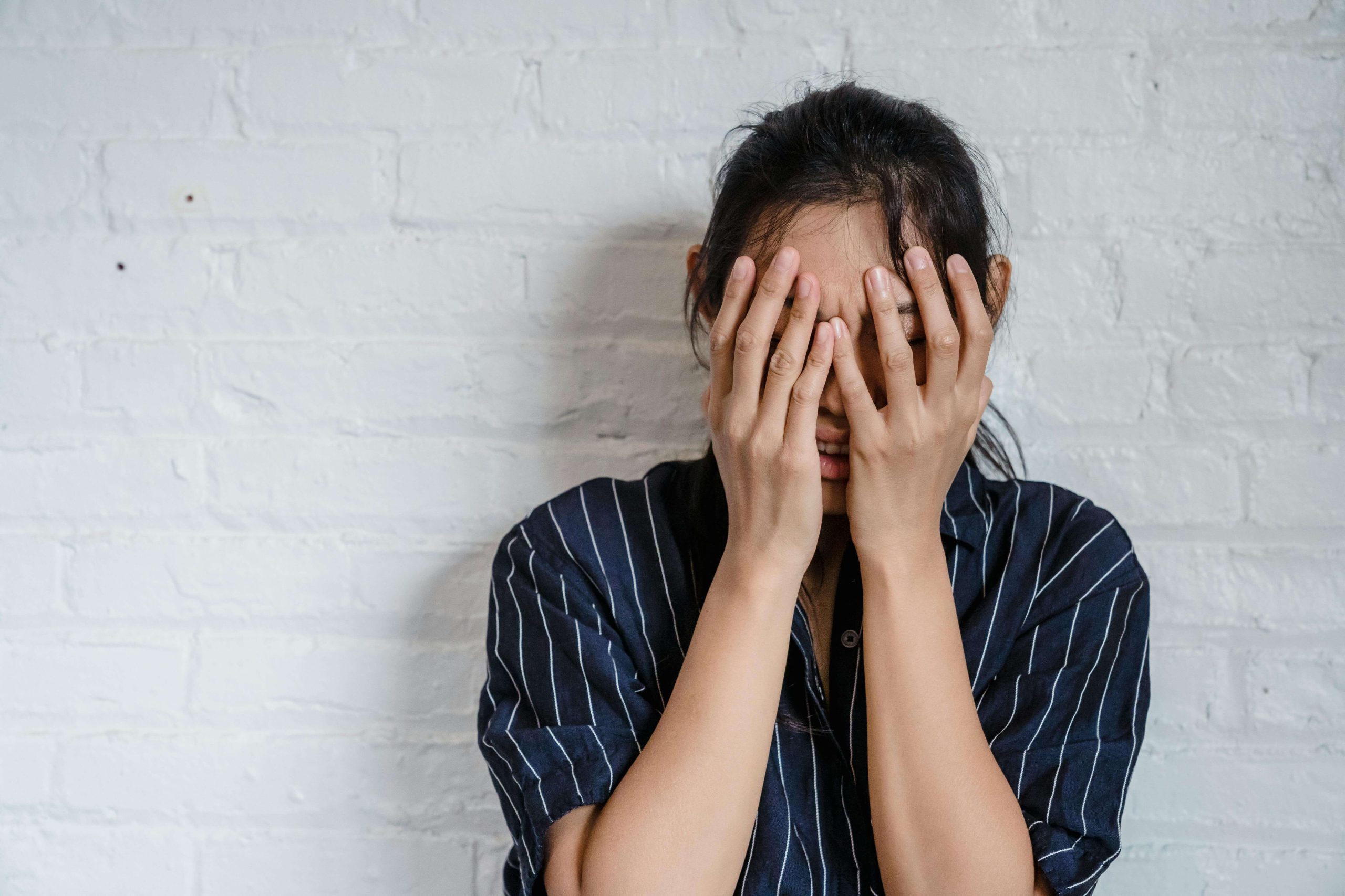 Woman holding her face in distress, showing the emotional struggles that psychiatry in Tempe AZ helps treat when cannabis use affects mood.